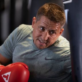 Man training with TITLE Boxing Club gloves.