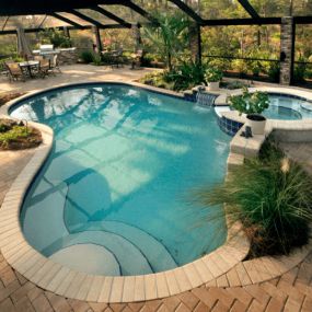 Kidney shaped pool with spa and beautiful landscape