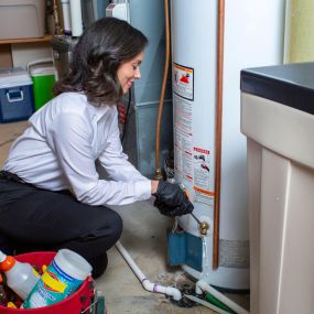 Technician Inspecting and Repairing a Water Heater in Tampa FL