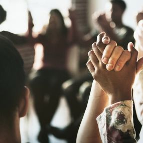 A group sits in a circle, holding hands during the Cornerstone of Southern California Group Therapy program in Orange County, symbolizing unity and support.