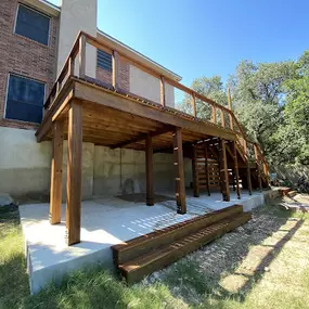 Custom ground-up deck build to replace existing deck, including structural slab, wire railings, staining, and custom stair