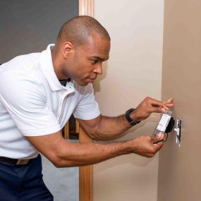 Electrician Installs New Dimmer Light Switch for Electrical Installation Service In a Residential Home