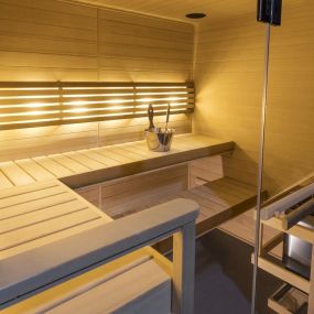 The exquisite Canadian Hemlock Sauna, emitting a comforting golden glow. Biodegradable exterior finish for luxury and easy care. Integrated lighting and Bluetooth sound elevate relaxation.