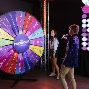 Game Show Host Playing Wheel of Wonder with Participant