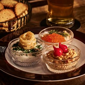 Several fine appetizers dips served at a bar