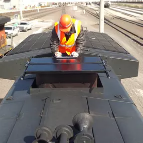 employee installing EMD Turbo Stack Cover: protects the engine from snow and rain during storage of the locomotive