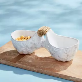 The Sea Double Serving Dish is a magnificent milk glazed terracotta double dip dish that will enhance any table setting. Its design is one-of-a-kind, with a center handle wrapped in rattan, giving it an elegant touch. Crafted from top-notch terracotta, this dish is not only visually appealing but also long-lasting. It is ideal for serving dips, sauces, or small appetizers. Whether you're throwing a dinner party or having a relaxed meal, this double serving dish is an essential addition to your k