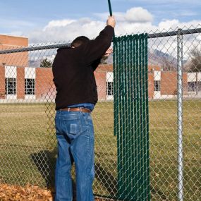 Contractor hand inserting privacy fence slats