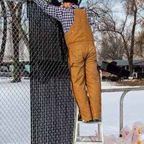 Contractor installing chain link privacy fence