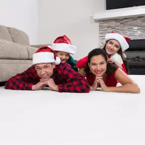 Family in holiday clothes lying on clean carpet