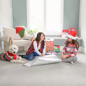 Family wrapping presents on clean carpet