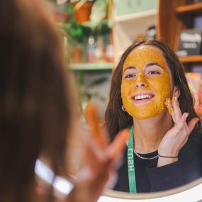 image of sales advisor using fresh face mask looking happy