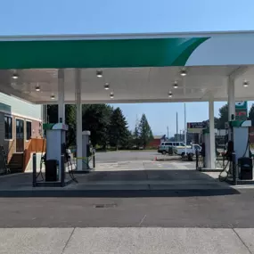 Gas station canopy and 4 pumps with Sinclair Wordmark.