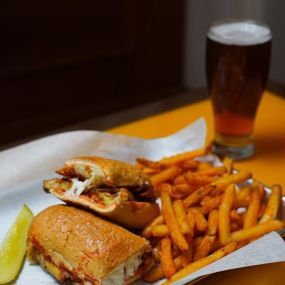 Craft beer with served with Italian sub sandwich, seasoned fries, and a pickle.
