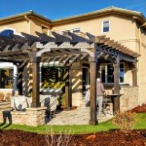 Custom pergola with outdoor kitchen and stone work