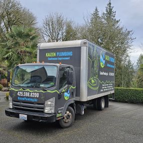 Kaizen Plumbing service truck outside a residential home on a cloudy day.