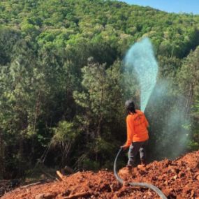 Man spraying hydroseed in a Beyond Site Solutions shirt.