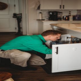 Man Inspecting for Bugs and Mice under kitchen sink