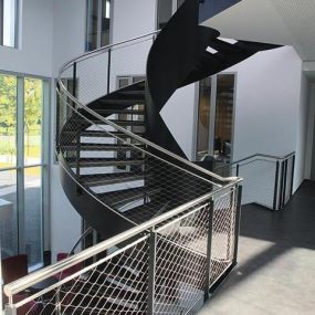 Stainless steel cable mesh hand railing for indoor stair safety by Carl Stahl DecorCable.