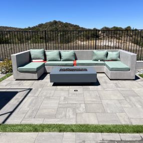 Custom bench with smooth stucco and precast fire pit with natural gas; large modern pavers with artificial turf strips, succulent and drought tolerant landscaping with low-voltage lights, new iron fence along the back of the property