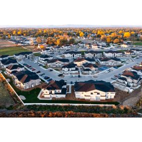 Aerial view of the property with ample parking and modern style townhome buildings