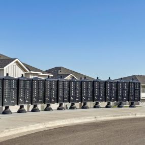 Large display of mail boxes in front of townhome buildings with a bright blue sky