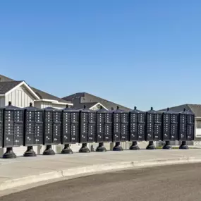 Large display of mail boxes in front of townhome buildings with a bright blue sky