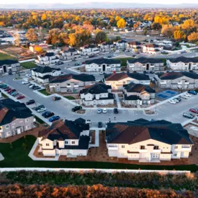 Aerial view of the property with ample parking and modern style townhome buildings