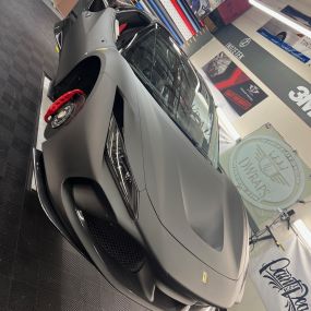 Dwraps installing a 3M wrap onto a Ferrari along with a window tint upgrade