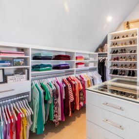 A vaulted ceiling closet with custom shelving and hang space