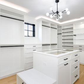 A large custom closet with hang space, drawers, shelving, and an island