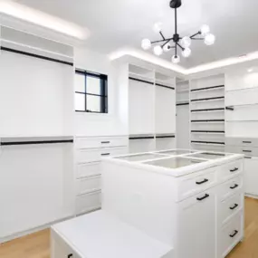 A large custom closet with hang space, drawers, shelving, and an island