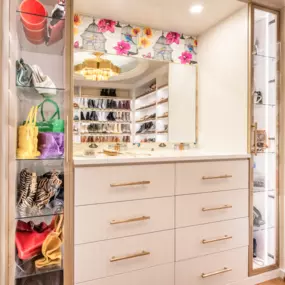 A custom vanity with white, gold, and glass detail