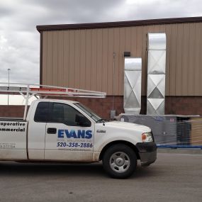 ductwork up the wall with air conditioner on the ground