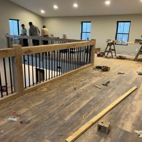 Putting in This beautiful custom built Faux Beam Staircase with black rod iron balusters, that over looks the livingroom. oak Faux beam banister. faux wood Staircase.