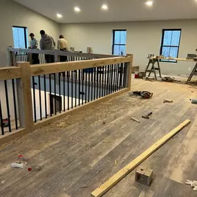 Putting in This beautiful custom built Faux Beam Staircase with black rod iron balusters, that over looks the livingroom. oak Faux beam banister. faux wood Staircase.