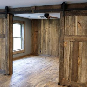 Stunning interior barnwood sliding double doors made from reclaimed wood, adding rustic charm and character to any space.