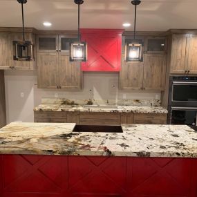 Kitchen with marble countertops and natural wood cabinets, combining elegance and warmth for a sophisticated look.