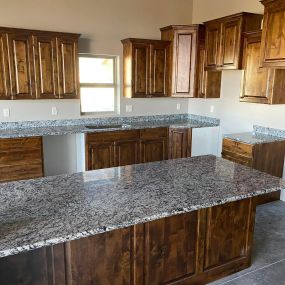 Kitchen with walnut cabinets and granite countertops for a warm and elegant ambiance.