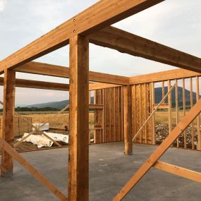 New home construction in the framing process, revealing a clean and organized construction site. Majestic mountains serve as a breathtaking backdrop, enhancing the scenic beauty of the scene.