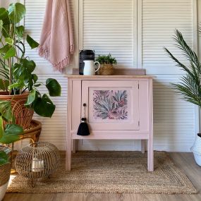 A side table that has been painted with Conch color in the Silk All-In-One Mineral Paint line and our decoupage paper applied to the front door.