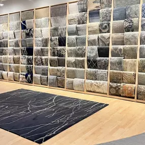 K. Powers rug display along long wall.