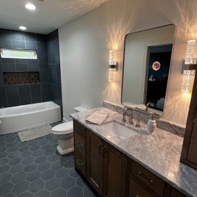 Bathroom remodel with slate tile floors, hardwood cabinets and marble countertops
