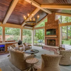 Outdoor kitchen patio with wine fridge, gas grill and fireplace.