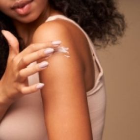 Desert Dermatology & Skin Cancer Specialists - woman spreading cream on arm