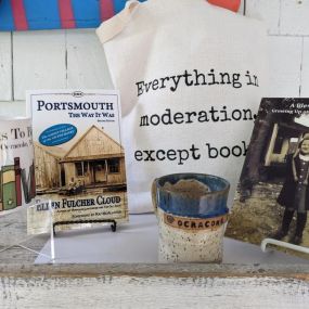 Mugs, Books, Home goods, canvas bags, and pottery are for sale at Books to be Red.