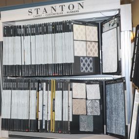 Display of Stanton carpet samples, featuring various patterns and textures. The bright lighting accurately showcases the colors and patterns. The organized display makes it easy for customers to browse and select their preferred style.