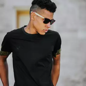 This image, developed by Sapien Designs' marketing Digital SEO, showcases a person wearing a black t-shirt with patterned sleeves, captured for digital marketing and SEO purposes.