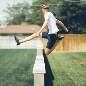 Image developed by Sapien Designs' marketing Digital SEO, showcasing a person in mid-air jumping over a concrete bench in a grassy area.