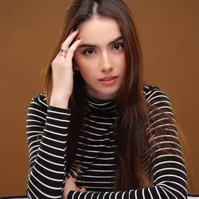 This image, developed by Sapien Designs' Marketing Digital SEO, showcases a person in a black and white striped shirt against a brown background.